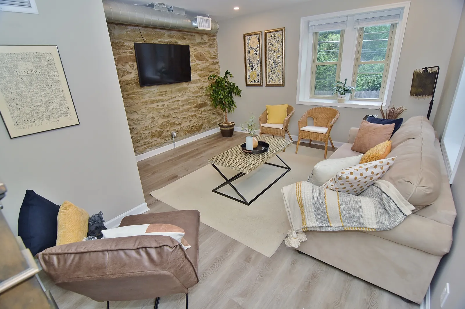 A warm and inviting living room featuring a stunning stone accent wall and plenty of comfortable seating for gathering with family and friends