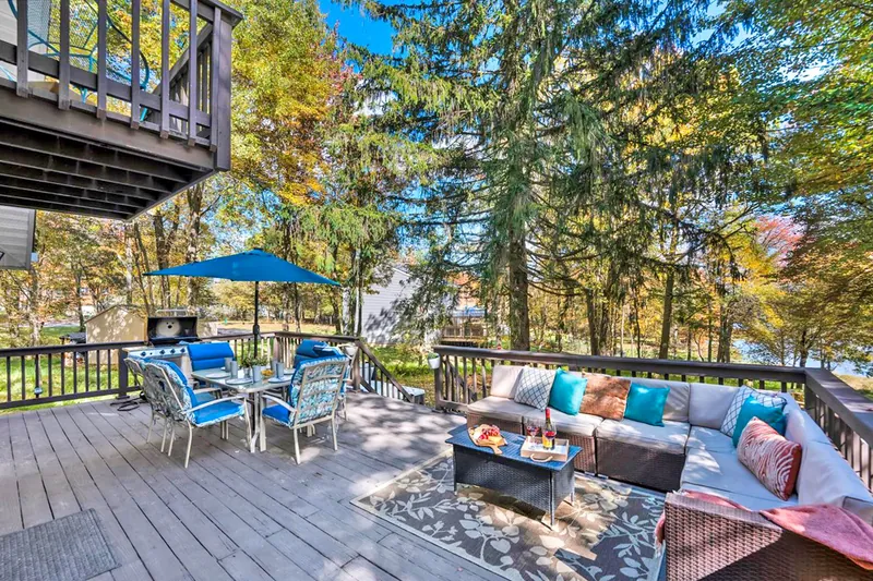 Spacious and inviting, the back deck features a cozy seating area, dining table and a grill. Perfect for gathering the whole group for outdoor meals and fun